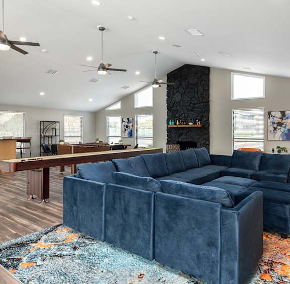 a living room with a blue couch and a pool table