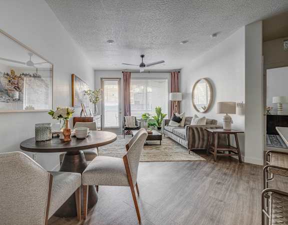 a living room and dining room with a table and chairs