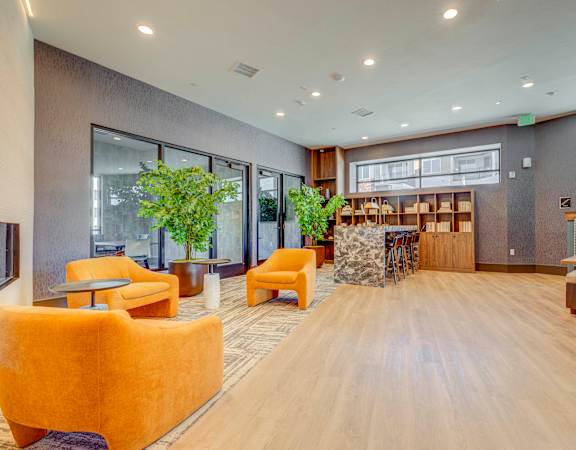 the lobby of a building with chairs and a table