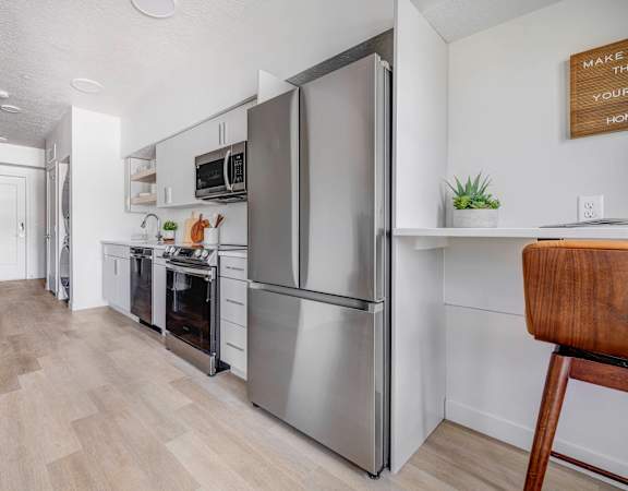 a kitchen with stainless steel appliances and a wooden floor