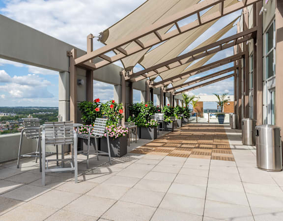 A patio with a table and chairs under a roof at Clayton on the Park Apartments, Clayton, Missouri