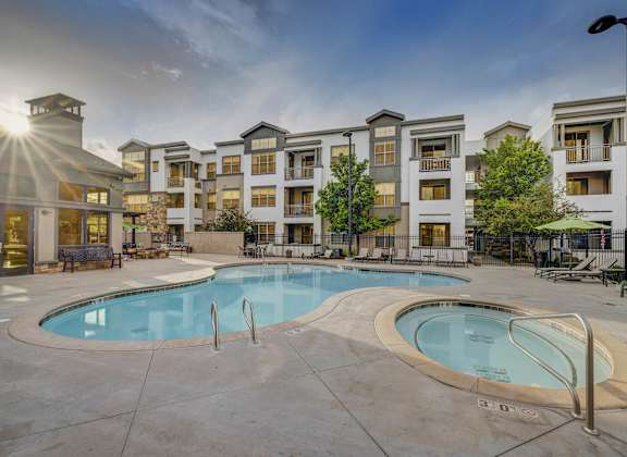 A large swimming pool in front of apartment buildings.