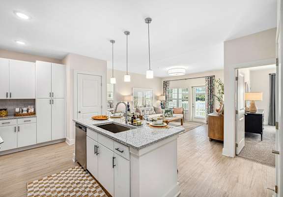 A kitchen with a sink, cabinets, and a dining table.