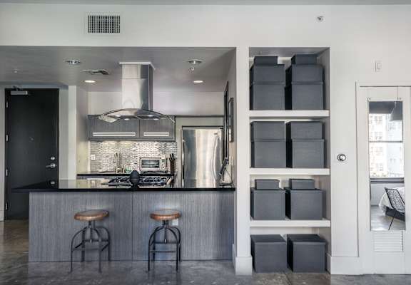 A modern kitchen with a bar area and a door leading to a balcony.