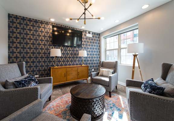 a living room with couches and chairs and a tv