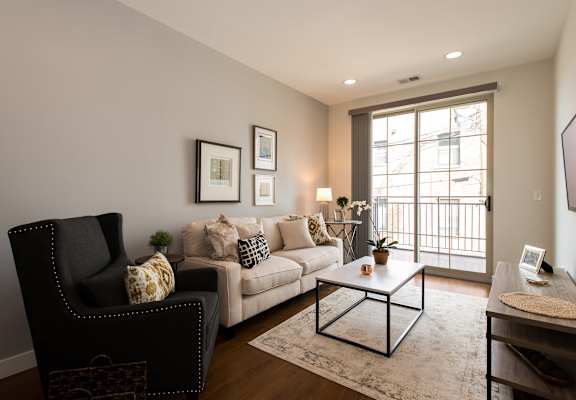 a living room with a couch and a chair and a window