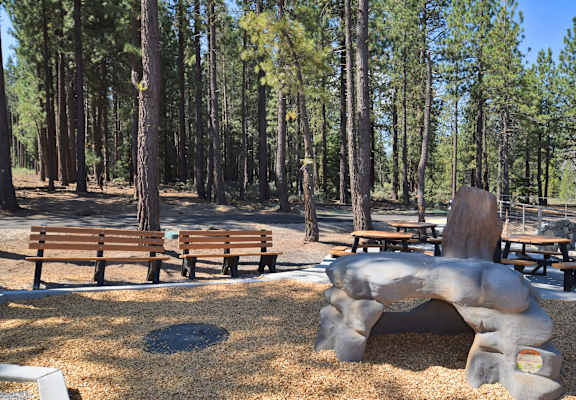 a sculpture of an elephant and benches in a park