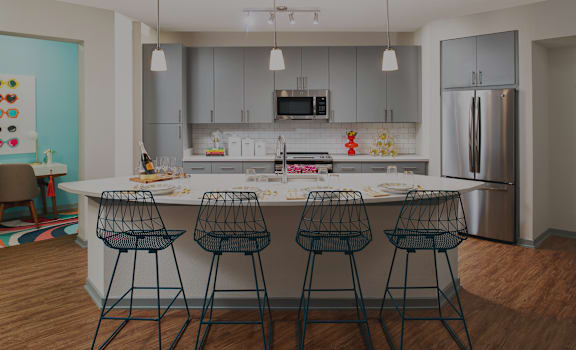 a kitchen with a island and four bar stools at The District at Rosemary, Sarasota, Florida