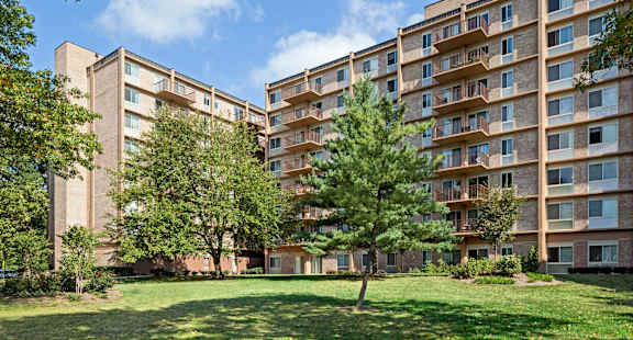 A large apartment complex with a green lawn in front.