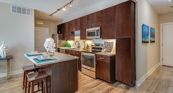 A kitchen with brown cabinets and a wooden island.