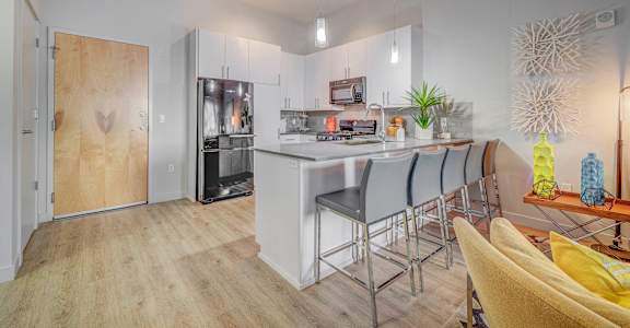A modern kitchen with a bar area and a dining table.
