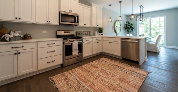 a large kitchen with white cabinets and stainless steel appliances