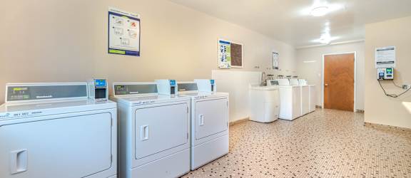 A laundry room with washers and dryers.