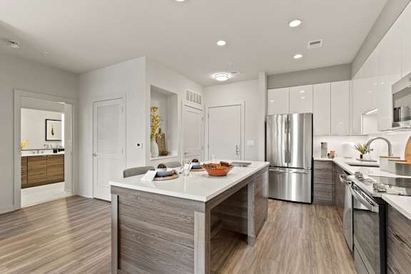 A modern kitchen with a center island and stainless steel appliances.