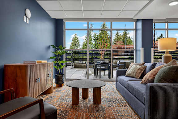 A living room with a blue couch and a wooden coffee table.