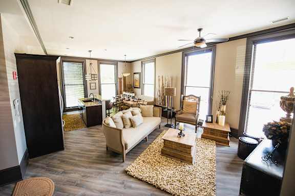 A living room with a white couch and a rug.
