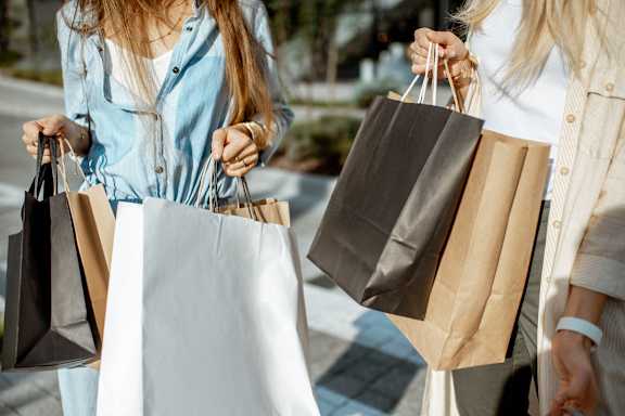 Two women holding shopping bags in their hands.
