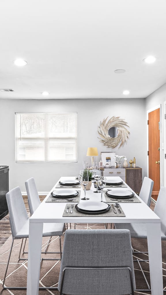 a dining room with a white table and chairs at Georgian Oaks Apartments, Smyrna , Georgia