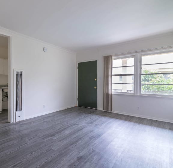 an empty living room with a stove and a window