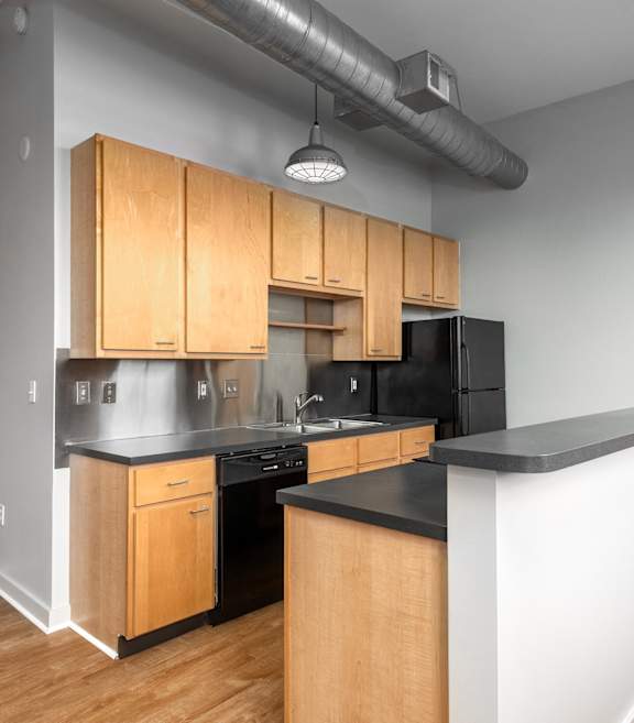 an empty kitchen with wooden cabinets and black counter tops