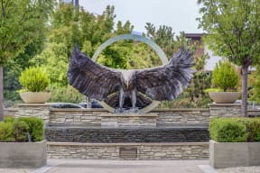 a statue of a bird of prey in front of a fountain