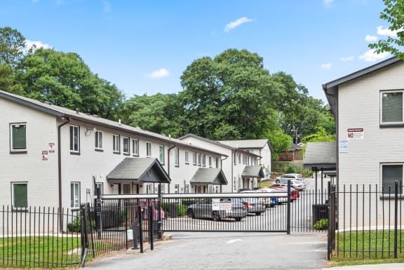 a row of white houses with cars parked in front of them