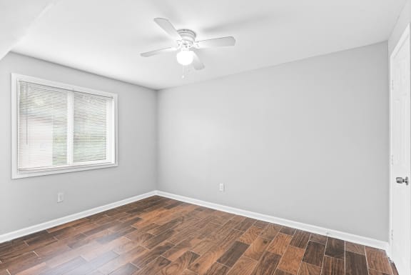 an empty room with a ceiling fan and a window