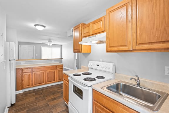 a kitchen with wooden cabinets and white appliances and a sink