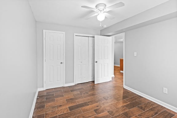 an empty room with a ceiling fan and a window