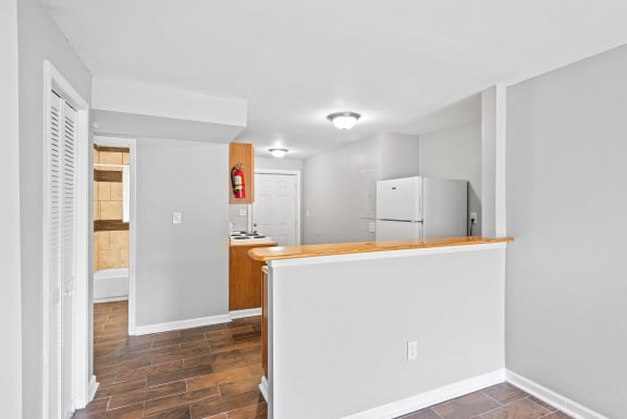 an empty kitchen with a counter top and a refrigerator