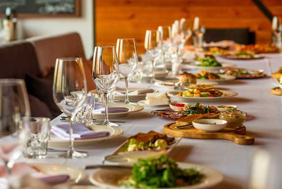 A long table is set with plates of food and glasses.