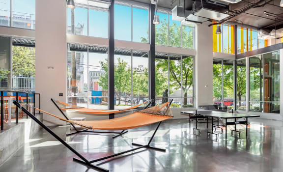 a pair of hammocks sit in the middle of a room in front of a large window at Cuvee, Seattle, Washington, 98122