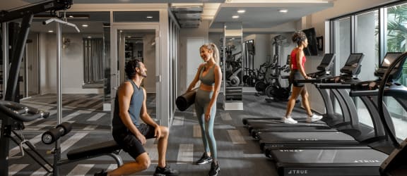 two men and a woman working out in a gym