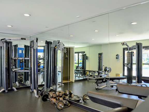 A gym with a variety of equipment including treadmills, weights, and exercise machines.at La Jolla Canyon Apartments, San Diego