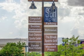 a sign for a lot of different restaurants in a parking lot
