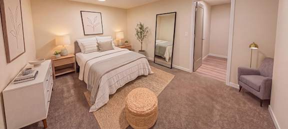A bedroom with a large bed and a chair.