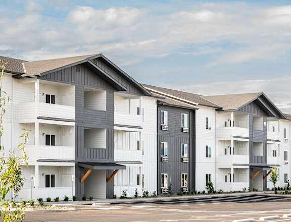 a row of white and gray apartment buildings with a parking lot at Gateway Apartments, East Wenatchee ,Washington, 98802