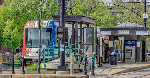 a bus stop on a city street with a train in the background