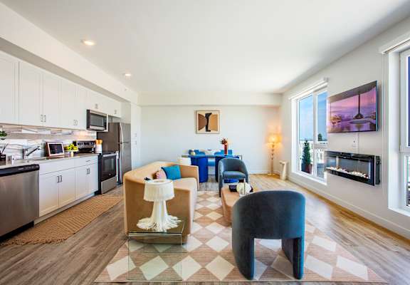 A modern kitchen with a dining area and a living room.