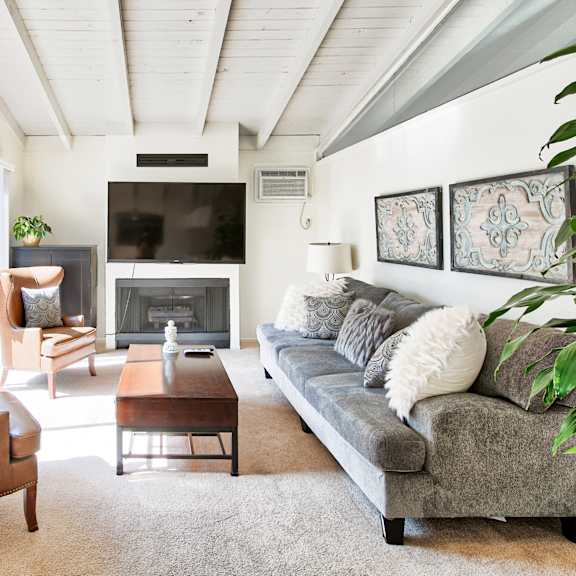 A living room with a grey couch and a brown chair.