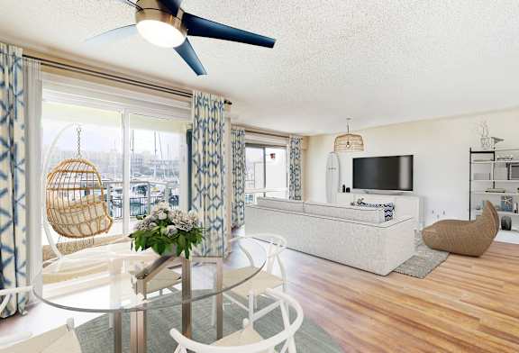 A living room with a glass table and a white chair.
