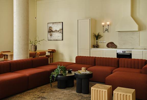 A living room with a red couch and a coffee table.