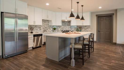 a kitchen with a large island and stainless steel appliances