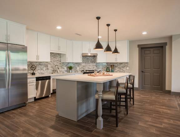 A kitchen with a large island and a refrigerator.