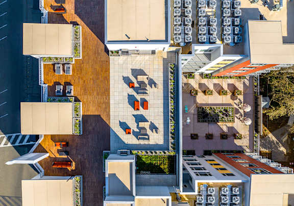 A parking lot with cars and a building with a red roof.