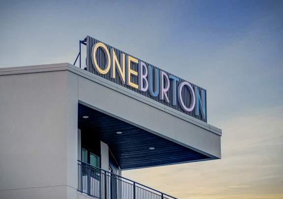 A building with a sign that says "ONE BURTON" on top.