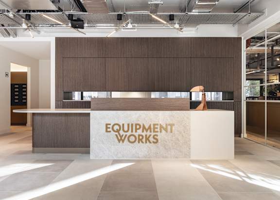 A reception area with a counter and a woman standing behind it.