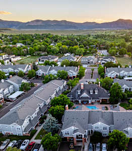 A sunset view of a residential neighborhood with houses and parked cars.