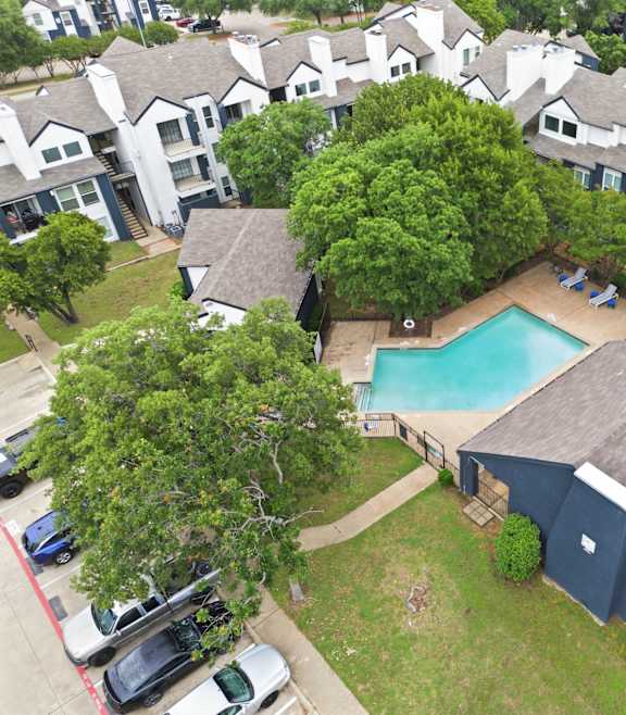 A bird's eye view of a residential area with a swimming pool.