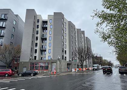 A grey building with a red car in front of it.